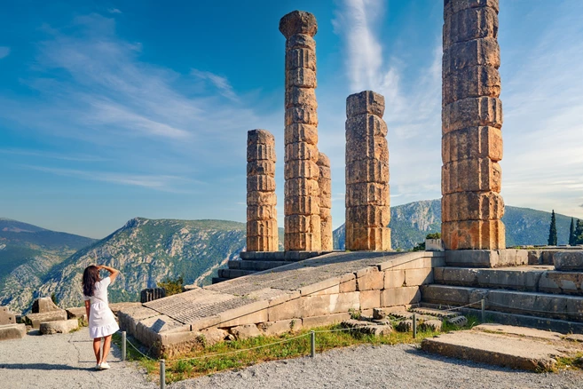 Delphi tourist admiring the columns of the ancient temple