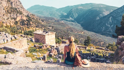 Delphi - tourist onlooking the ruins of the temple of Apollo